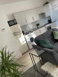 a living room with a couch and a kitchen at Cosy modern one bedroom flat in Hartlepool