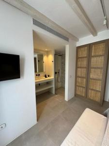 Habitación con baño con lavabo y TV. en Vivant Naousa Residence 3, en Naousa