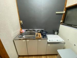 a small kitchen with a sink and a stove at 【浅草・秋葉原・銀座・スカイツリー・東京タワー他直通！】最大8人 in Tokyo