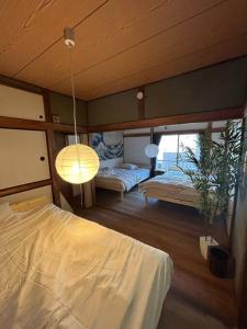 a bedroom with two beds and a lamp at 【浅草・秋葉原・銀座・スカイツリー・東京タワー他直通！】最大8人 in Tokyo