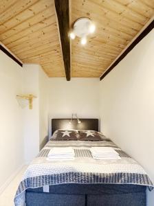 a bedroom with a bed with a wooden ceiling at Kåseberga Byhus in Ystad