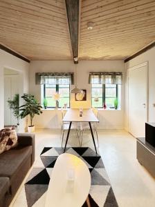 Kåseberga Byhus في إيستاد: غرفة معيشة مع طاولة وأريكة