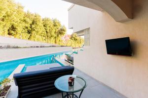 a patio with a table and a tv on a wall at The V Luxury Resort Sahl Hasheesh in Hurghada