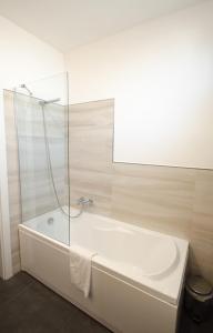 een badkamer met een wit bad en een spiegel bij Sea Salt in Porto Cesareo