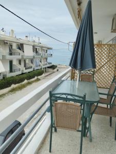 - Balcón con mesa, sombrilla y sillas en Assos Beach, en Káto Ássos