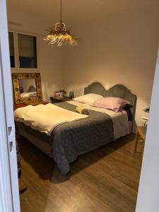 a bedroom with two beds and a chandelier at Cocon de douceur à deux pas de la gare in Montauban-de-Bretagne