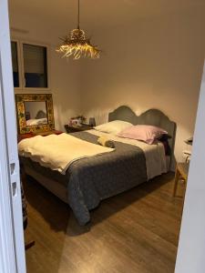 een slaapkamer met 2 bedden en een kroonluchter bij Cocon de douceur à deux pas de la gare in Montauban-de-Bretagne