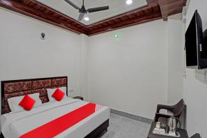 um quarto com uma cama com almofadas vermelhas e um tecto em Flagship Shree Shyam Residency em Nova Deli
