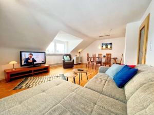 uma sala de estar com um sofá e uma televisão de ecrã plano em Ferienwohnung-Schweinfurt em Schweinfurt