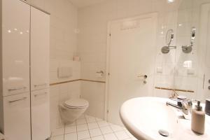 a white bathroom with a toilet and a sink at Blick auf's Schloss in Itter +42 photos