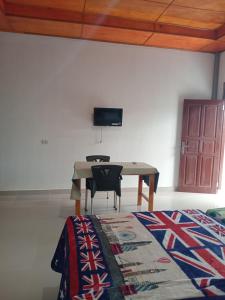 um quarto com uma mesa e uma televisão na parede em Matraville guesthouse em Tuktuk Siadong