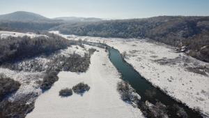 einen Luftblick auf einen Fluss im Schnee in der Unterkunft SMARAGD RIVER near Rastoke & Plitvice Lakes in Slunj