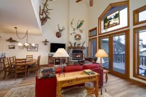 een woonkamer met een rode bank en een tafel bij CrossTimbers 2784 Holiday home in Steamboat Springs