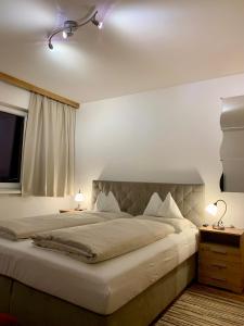 a bedroom with a large bed and a window at Almlodge Flachau in Flachau