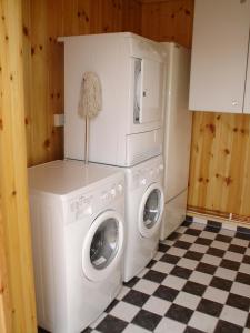 een wasmachine en droger in een keuken met een geruite vloer bij Markusfolks Gård in Torsby