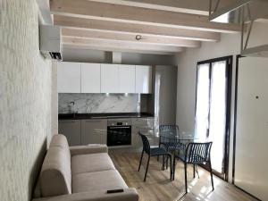 a living room with a couch and a table and chairs at Maestrale Apartment - 150 from the beach in Fano +9 photos
