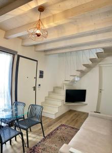 a living room with a table and chairs and a staircase at Maestrale Apartment - 150 from the beach in Fano
