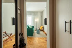 a hallway with a living room with a green couch at Syntagma Bliss: Athens Hub in Athens