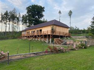 une grande maison en bois dans un champ avec une cour dans l'établissement Zámeček Waldsteinovo Zátiší, à Svatoslav