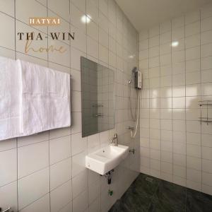 ハジャイにあるTha-win Home-City Charm Adventure with stylish Hat Yai retreatの白いバスルーム(シンク、鏡付)