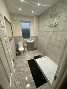 La salle de bains est pourvue d'une baignoire, de toilettes et d'un lavabo. dans l'établissement Three Bedroom Flat, Camborne Avenue W13, à Londres