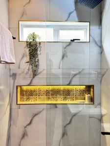 a bathroom with a window and a shelf with a plant at The Croft Homes -Kampala Buwatte in Wakiso