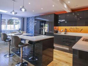 a kitchen with a large island with bar stools at Magnolia House in Reading