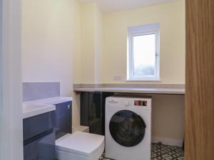 a washing machine in a kitchen with a window at Magnolia House in Reading