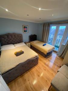 - une chambre avec deux lits et un canapé dans l'établissement Three Bedroom Flat, Camborne Avenue W13, à Londres