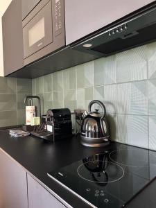 a tea kettle on a stove in a kitchen at Luksusowy apartament Ryn Mazury Widok na Jezioro, Gorąca BALIA in Ryn