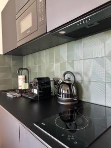 a tea kettle on a stove in a kitchen at Luksusowy apartament Ryn Mazury Widok na Jezioro, Gorąca BALIA in Ryn +14 photos