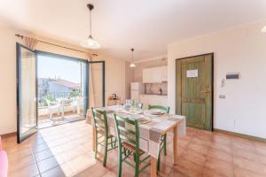 a kitchen and dining room with a table and chairs at Quaint Residence I Mirti Bianchi n6978 in Santa Teresa Gallura