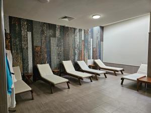 a waiting room with white chairs and a wall at Hotel Alisa in Pavel Banya