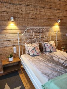 a bed in a room with a wooden wall at Old Town Family Apartment in Valga