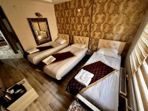 a hotel room with two beds and a mirror at Hotel Seven Park in Nevsehir