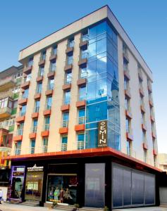 un gran edificio con ventanas de cristal en una calle en Laleli Emin Hotel, en Estambul