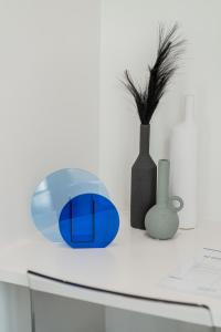ブルージュにあるMaison Brugesの白い机と青い花瓶、花瓶