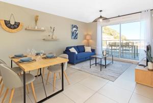 a living room with a dining table and a blue couch at Luxury apartment - Sea View - Private parking in Beausoleil
