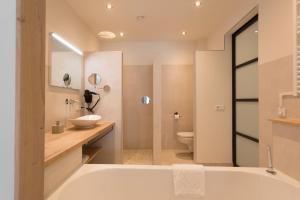 uma casa de banho com uma banheira, um lavatório e um WC. em Zeayou Zeeland - Studio's Zuidstraat 1 em Domburg