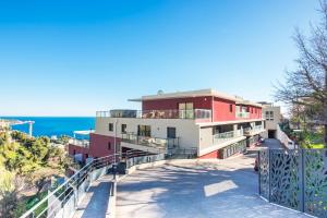 een gebouw op een heuvel met de oceaan op de achtergrond bij Luxury apartment - Sea view - Private parking - BP in Beausoleil