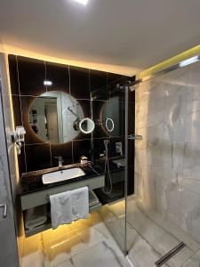 The Conforium Hotel Van في فان: حمام مع دش ومغسلة ومرآة