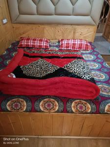 uma cama com um cobertor vermelho em cima em HOTEL TOWN PALACE SRINAGAR em Srinagar