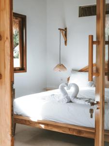 a bedroom with a bed with two swans on it at Luana Lombok in Selong Belanak