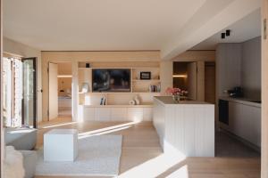 cocina grande con armarios blancos y sala de estar. en MeinNATURGUT mit Sauna, en Oberstaufen