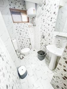 een witte badkamer met een wastafel en een toilet bij HOTEL TOWN PALACE SRINAGAR in Srinagar