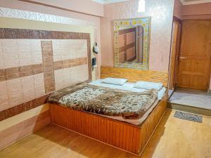 Cama pequeña en habitación con espejo en HOTEL TOWN PALACE SRINAGAR, en Srinagar