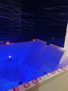 a pool in a room at night with purple lights at Relax Room proche PARIS Porte de Versailles in Malakoff