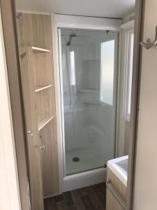 a shower in a bathroom with a glass door at Verblijfpark Tulderheyde - Leisure only! in Poppel