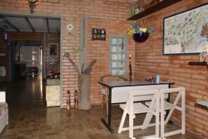 um quarto com uma mesa e cadeiras e uma parede de tijolos em Pousada do Beijaflor em Florianópolis