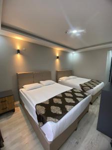 two beds in a small room with two at Whitestone Hotel in Nevsehir